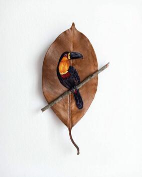 Артистка бродира птици върху сухи листа