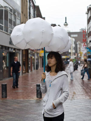 Идеята на този "чадър-облаче" е да предизвиква усмивки в мрачните дъждовни дни. Дръжката му представлява своеобразна помпа, която надува интересната форма от снимката.